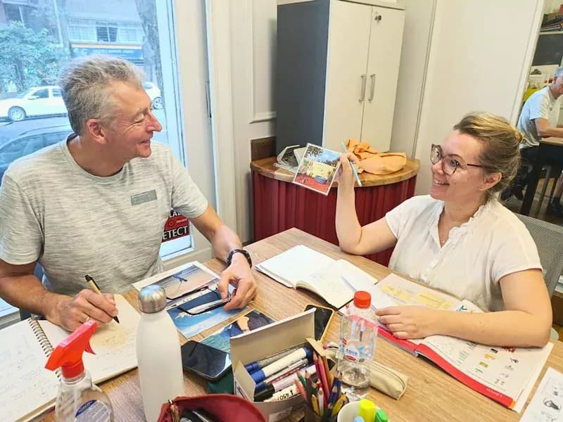 Two adult Spanish students engaged in conversation during a classroom activity