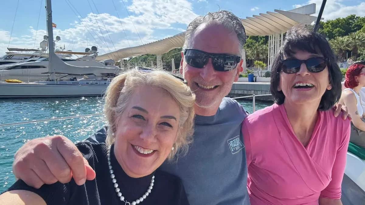 Two women and a man from the 50+ Program smiling together during a boat excursion in Málaga.