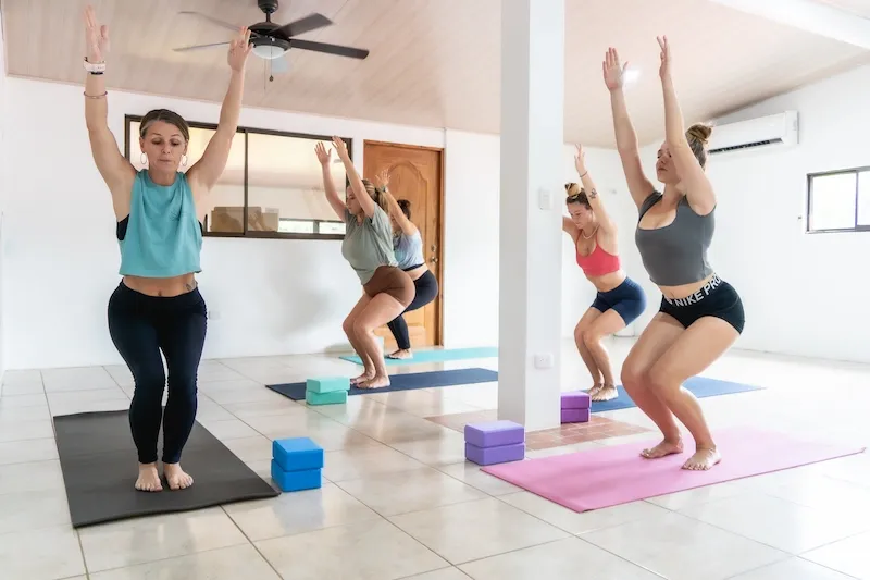 Students practicing standing yoga poses during a group class at Expanish Costa Rica
