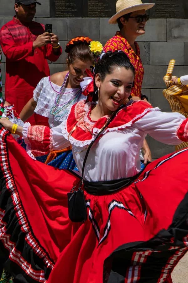 Dancers in colorful traditional Costa Rican attire performing lively choreography.