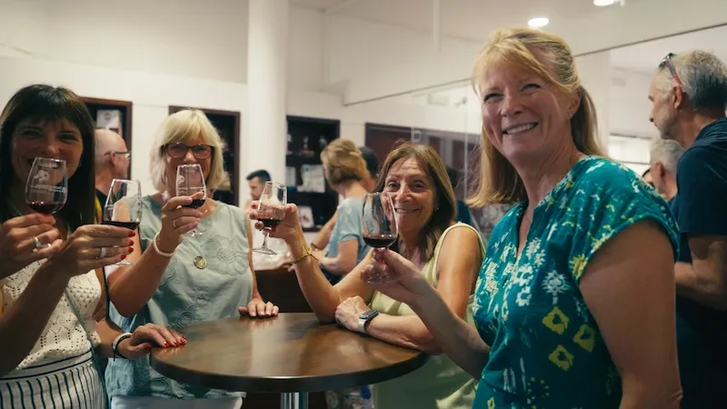 50+ Program students raising glasses together during a wine tasting activity.