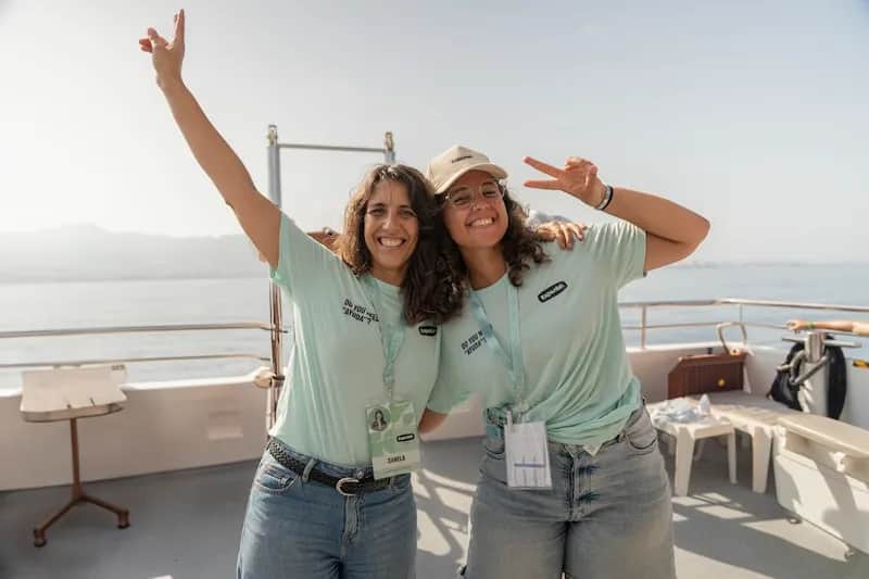 Two Expanish summer camp staff members smiling and posing on a boat in Málaga.