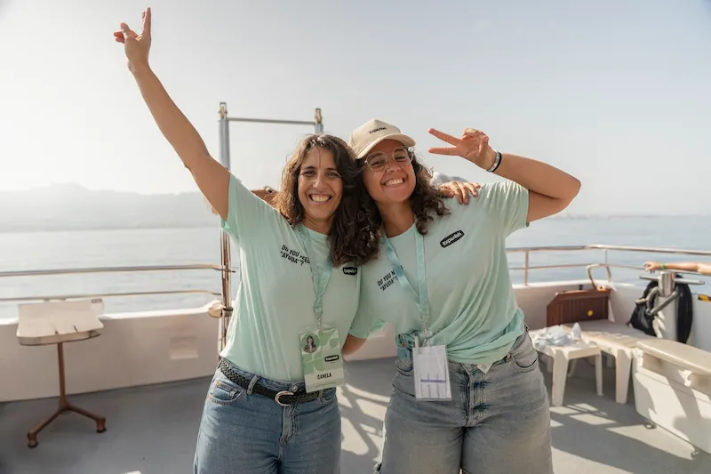 Two Expanish summer camp staff members smiling and posing on a boat in Málaga.