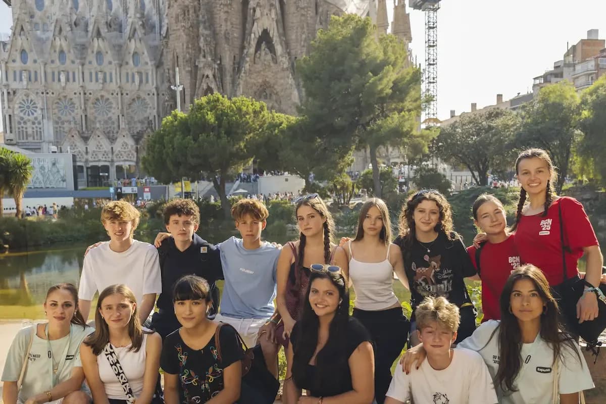 Expanish summer camp students posing together near the Sagrada Família in Barcelona.
