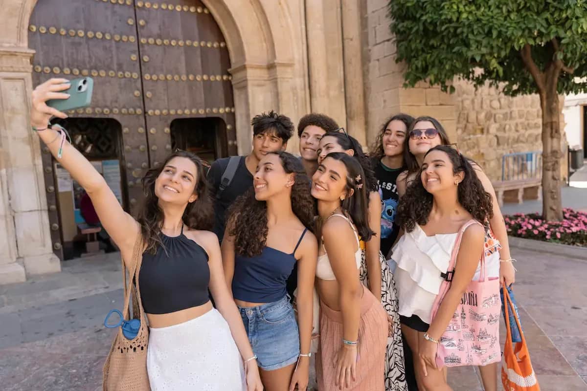 Expanish summer camp students taking a group selfie together during a city outing.