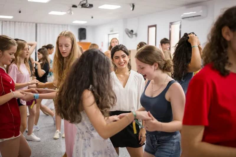Expanish summer camp students participating in a lively dance workshop together.