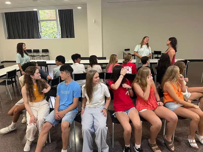 Expanish summer camp students participating in an interactive group game inside a classroom.