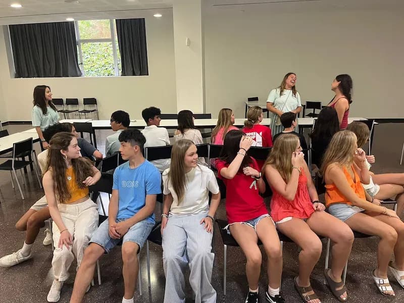 Expanish summer camp students participating in an interactive group game inside a classroom.