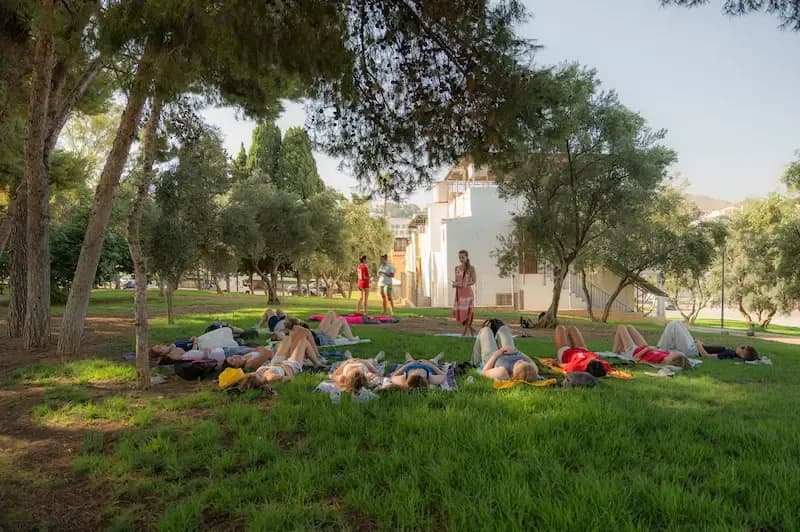 Expanish summer camp students lying on the grass during a peaceful outdoor activity.
