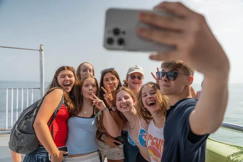 Expanish summer camp students taking a cheerful group selfie during a activity.