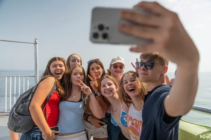 Expanish summer camp students taking a cheerful group selfie during a activity.